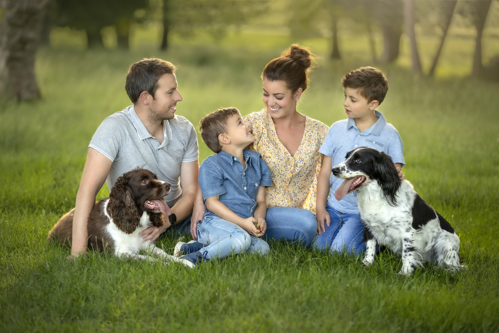 beautiful fine art family photograph with mom dad two boys and their pet dogs