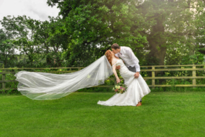Beride & grrom kissing as he dips her back. Her veil floating down behind her