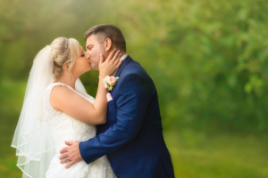romantic photo of bride wearing a bridal veil kissing her husband