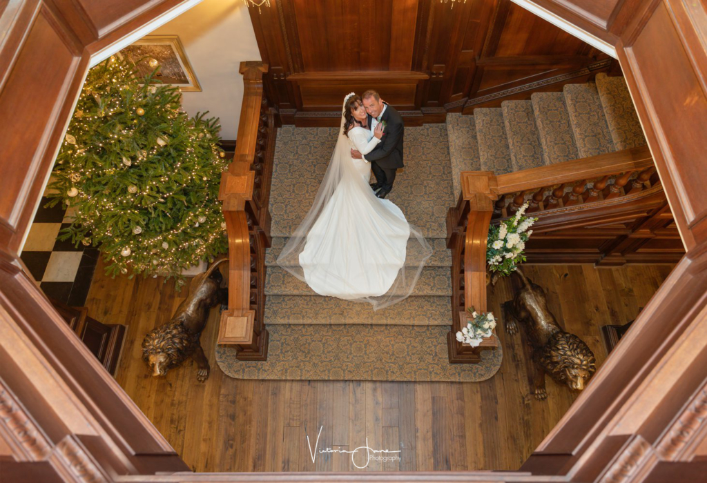 couple stainding on the beautiful grand staircase inside Bourton Hall