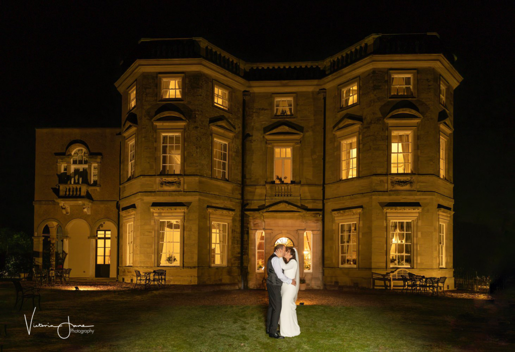 Nighttime shot of bride & groom outside Bourton Hall at night